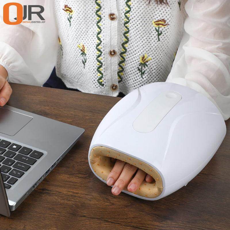 Air compression hand massager shown being used on a desk